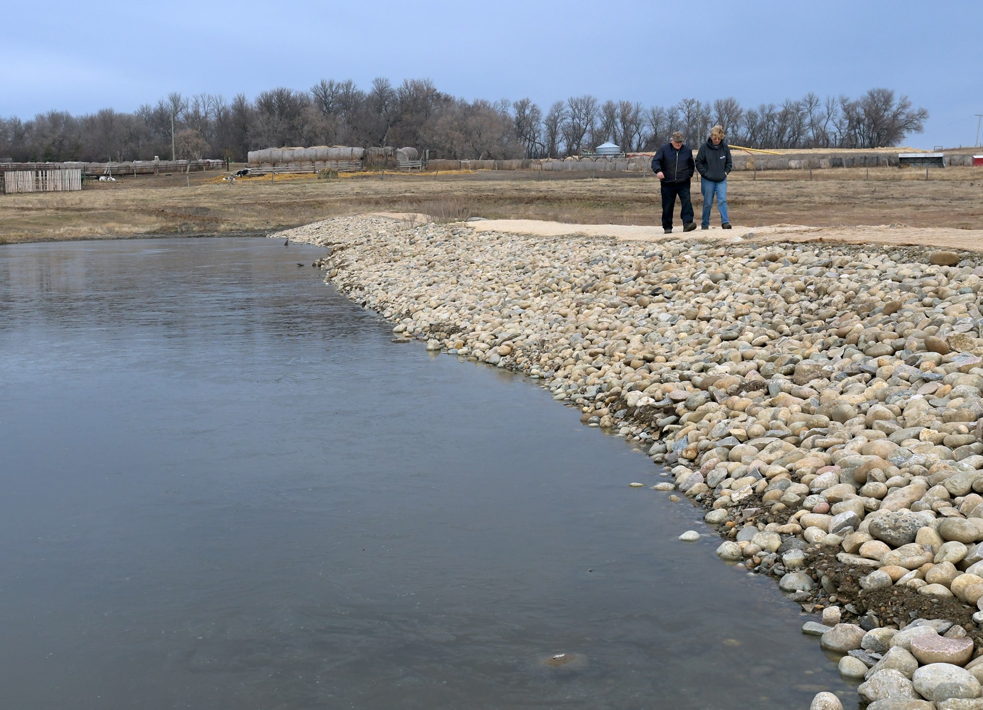 Dodds and Janssens walk along the rebuilt DUC water control structure on their farm near Kenton (photo DUC)